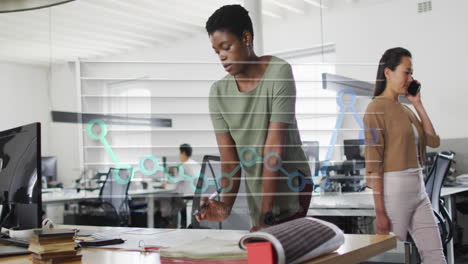 animation of month names and graph over african american woman working on blueprint in office