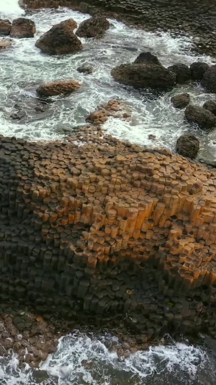 Video aereo in formato social di pietre al Selciato del Gigante a Bushmills, Contea di Antrim nell'Irlanda del Nord, Regno Unito. Prodotto in formato verticale 1080x1920 con colore Rec709