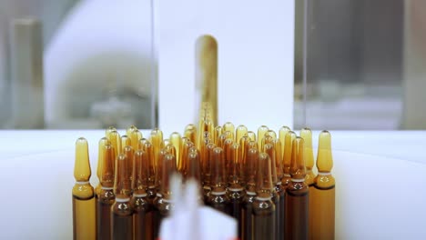 medical vials on conveyor belt. medicine ampoules manufacturing line