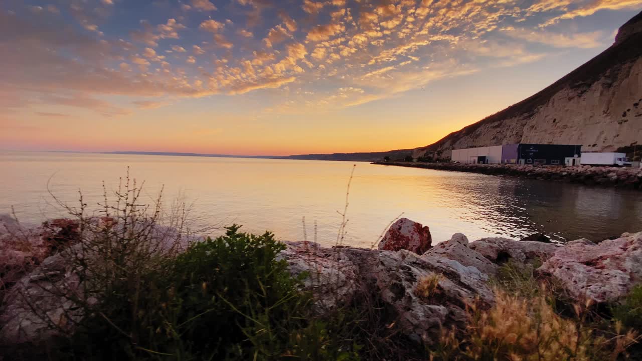 puesta de sol de ensueño sobre el mar negro con roca en primer plano