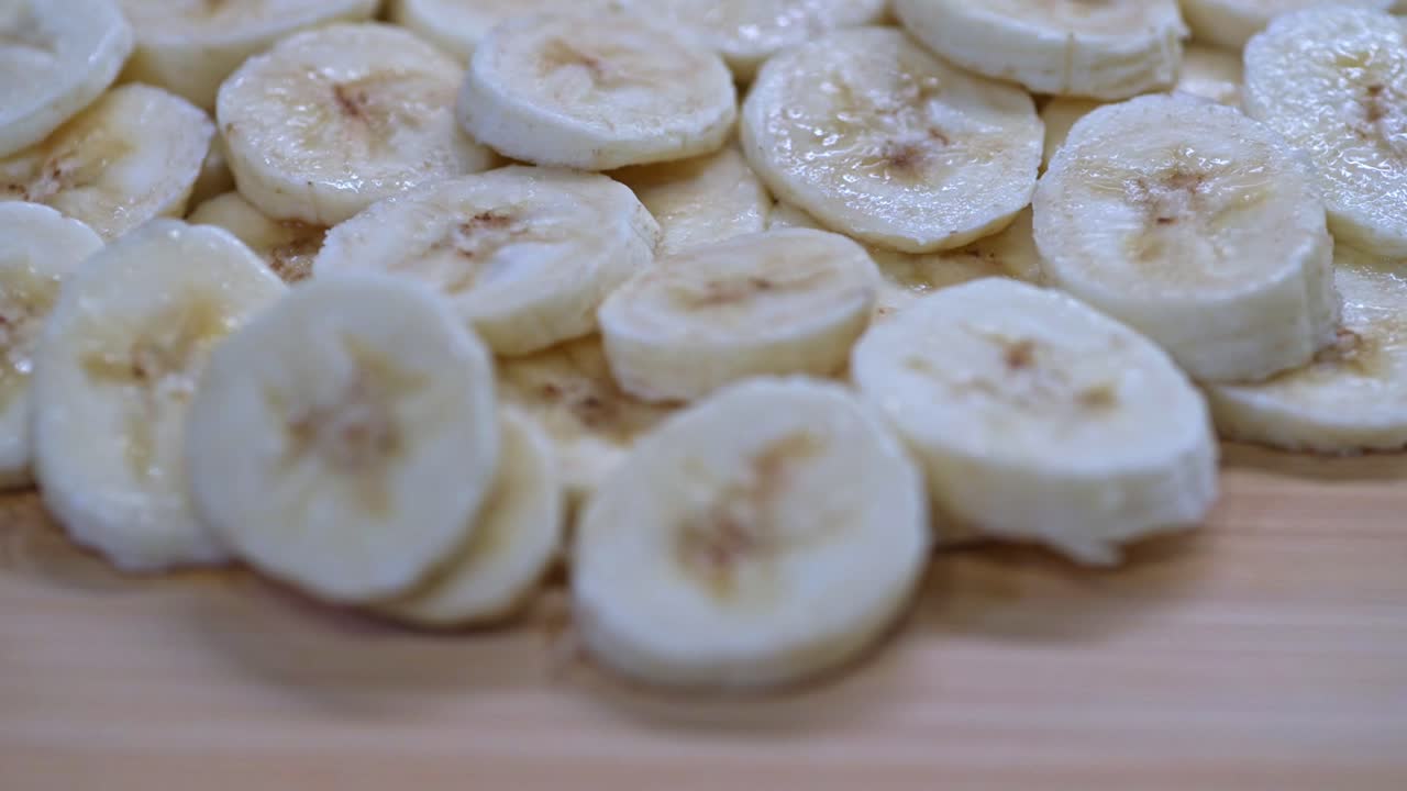 A close-up view of freshly sliced bananas on a wooden table.