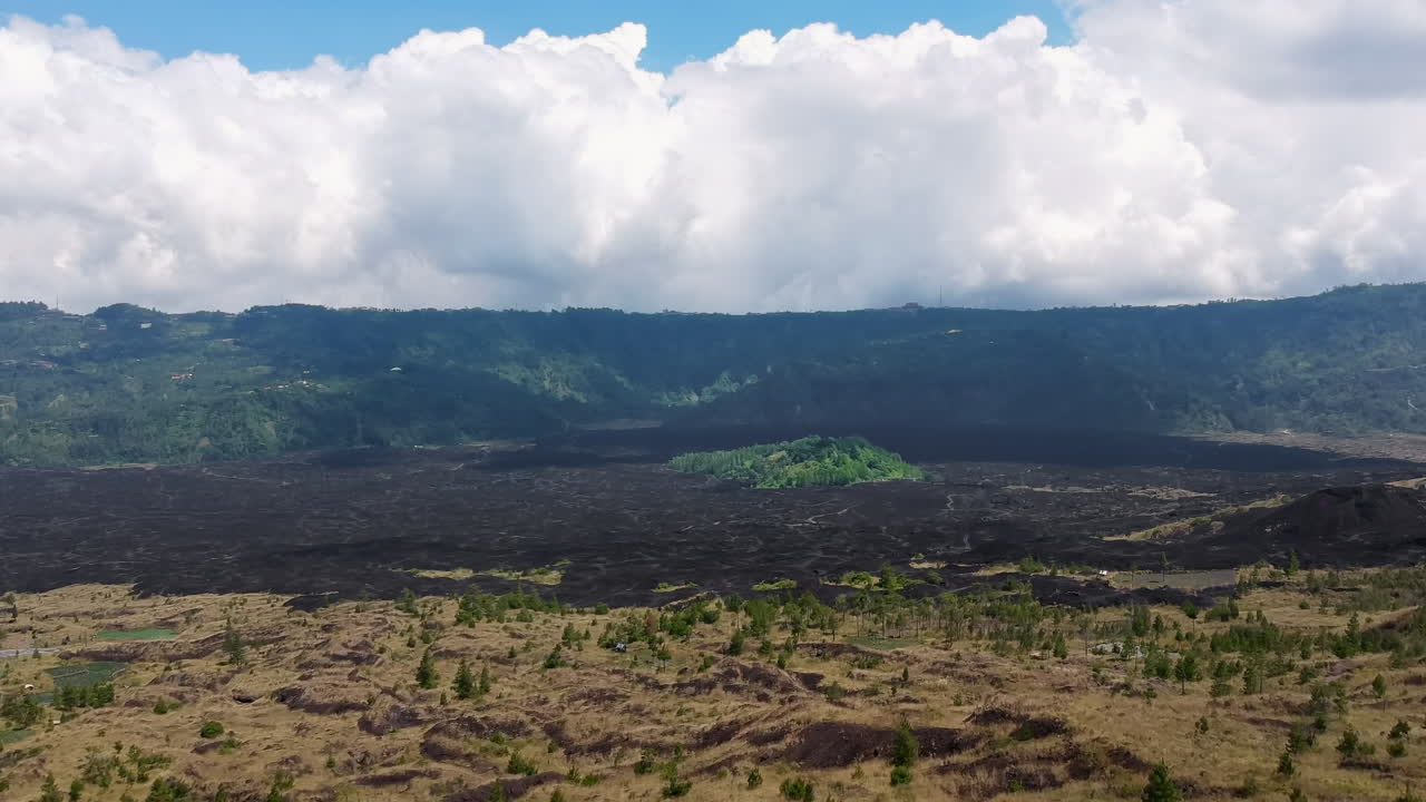 Droneoptagelse, luftfoto af en grøn planteø midt i vulkansk aske (Pura Perapen Batur)