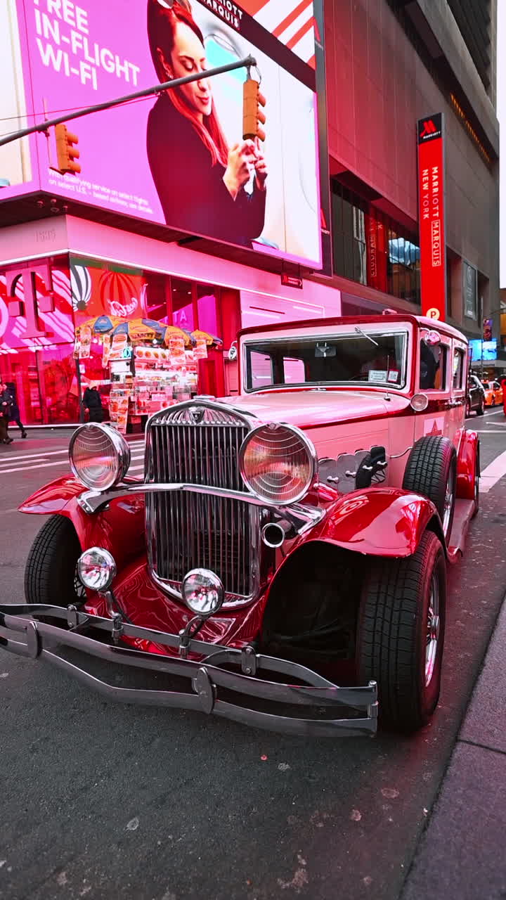 New York, USA, 8 October 2025: Vintage car at Times Square glow. Classic red car stands under bright Times Square lights in New York City