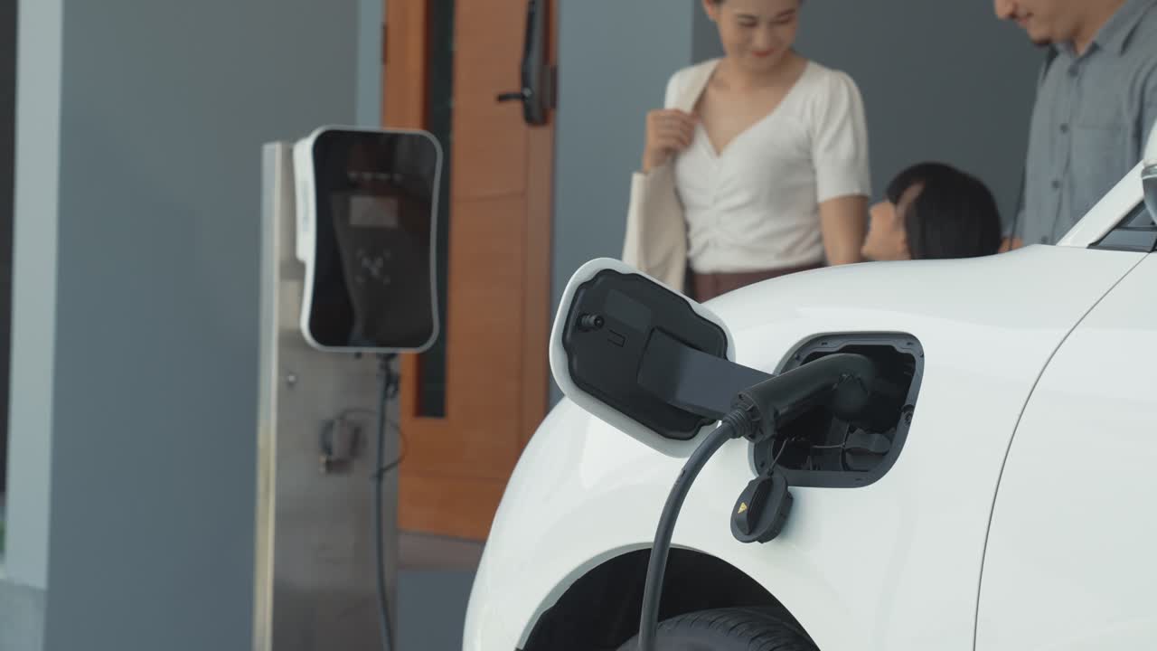 los padres progresistas han regresado de recoger a su hija en la escuela con el coche ev.