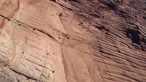 Rocky-cliffs-and-sandy-ground-on-sunny-day-in-desert-terrain