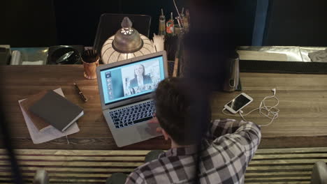 Top-View-Of-Businessman-In-Plaid-Shirt-Sitting-At-Desk-On-Video-Call-With-Businesswoman-Dressed-In-Suit-Jacket