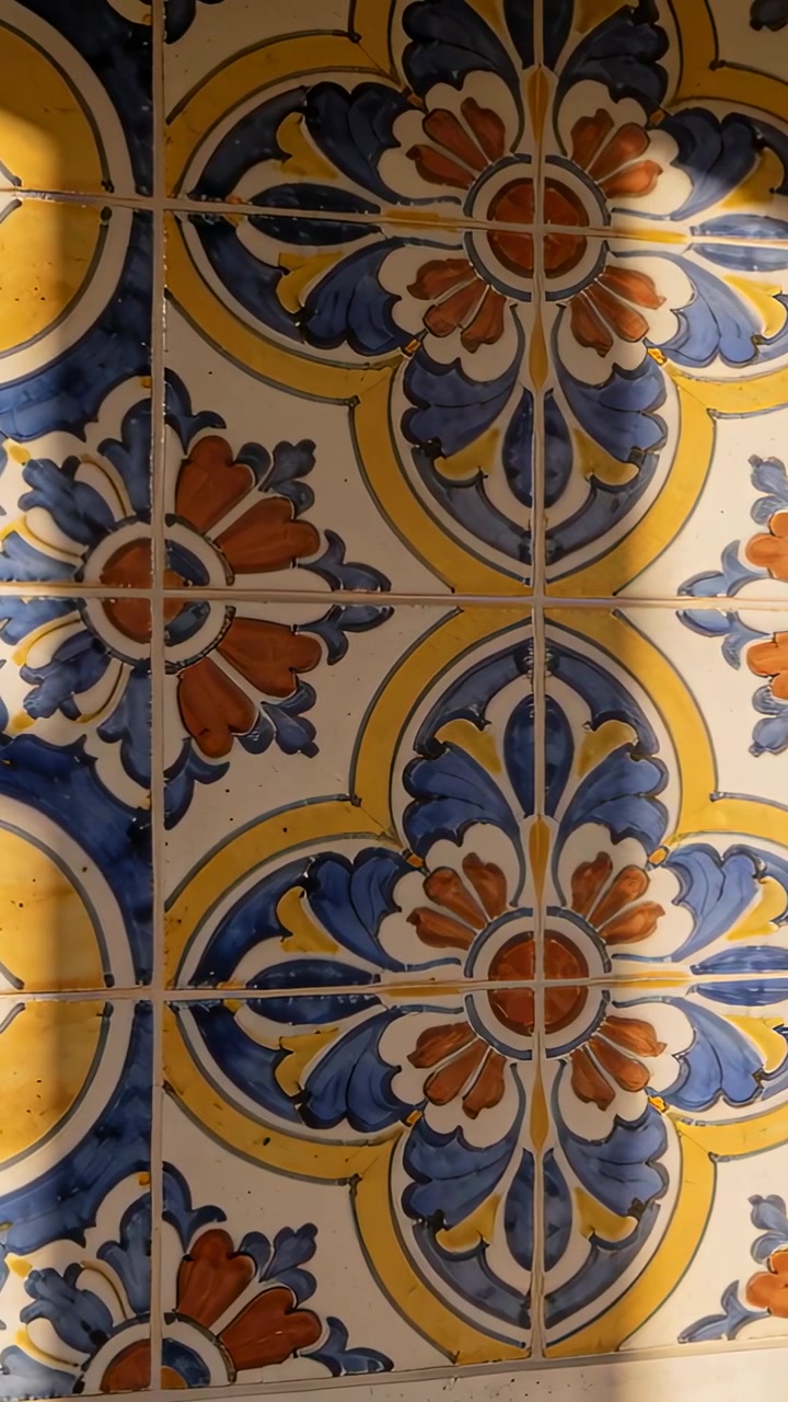 Video verticale: Telecamera che panoramica seguendo un'ombra che passa su piastrelle di ceramica a parete, mostrando le fughe.