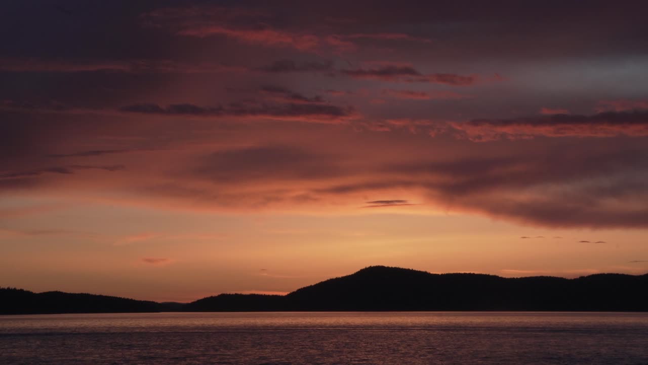 Picturesque Sunset Sky Over Silhouetted Mountains At Washington Park In Anacortes, Washington USA. Panning Shot