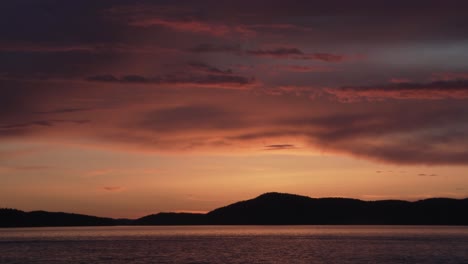 picturesque sunset sky over silhouetted mountains at washington park in anacortes, washington usa. panning shot