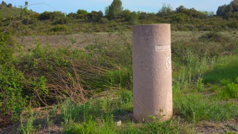 Via-Augusta-Marcador-De-Hormigón-En-El-Campo-De-Hierba-En-La-Provincia-De-Castellon,-España