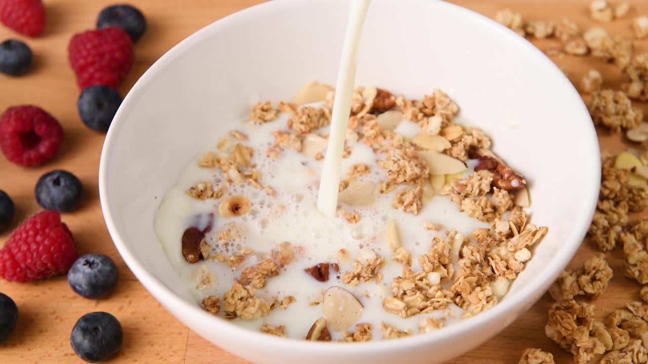 tiro de leche vertida en un tazón de granola