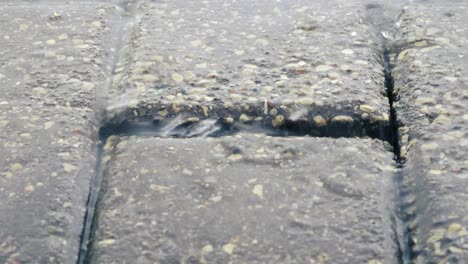 Raindrops-fall-on-a-paved-road