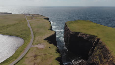 a sweeping aerial shot of a sea gorge with crashing waves in west shetland,scotland