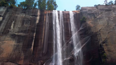 Tiro-Lento-Inclinado-Hacia-Arriba-Desde-La-Roca-En-Primer-Plano-Para-Revelar-Cataratas-Primaverales