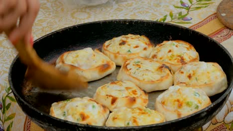 chef picking up hot pies with chicken and cheese