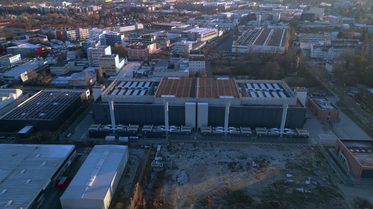 Large big data center building with advanced cooling systems, providing digital infrastructure in a city Berlin. Smooth aerial view drone camera pointing down