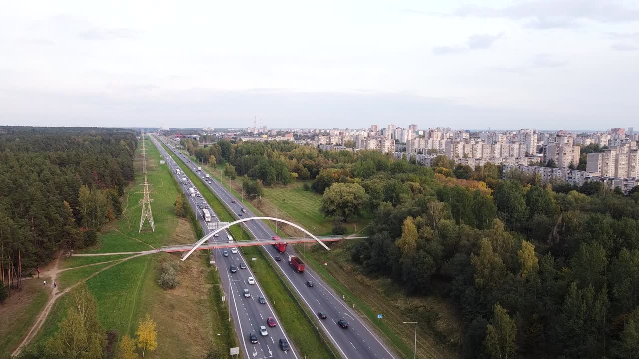 статичный снимок с беспилотника жилого района города каунас над шоссе а1 с интенсивным движением и пешеходным мостом вдали