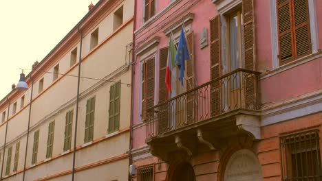 Banderas-De-Italia-Y-La-Unión-Europea-En-La-Fachada-Del-Edificio-En-El-Casco-Antiguo-De-Forli,-Emilia-romagna,-Italia