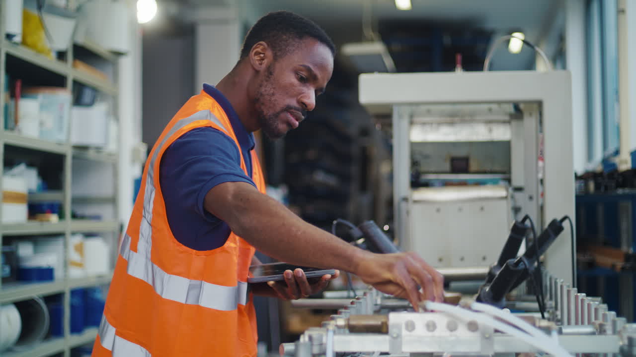 African american worker operating in a metal manufacturing facility using a digital tablet for