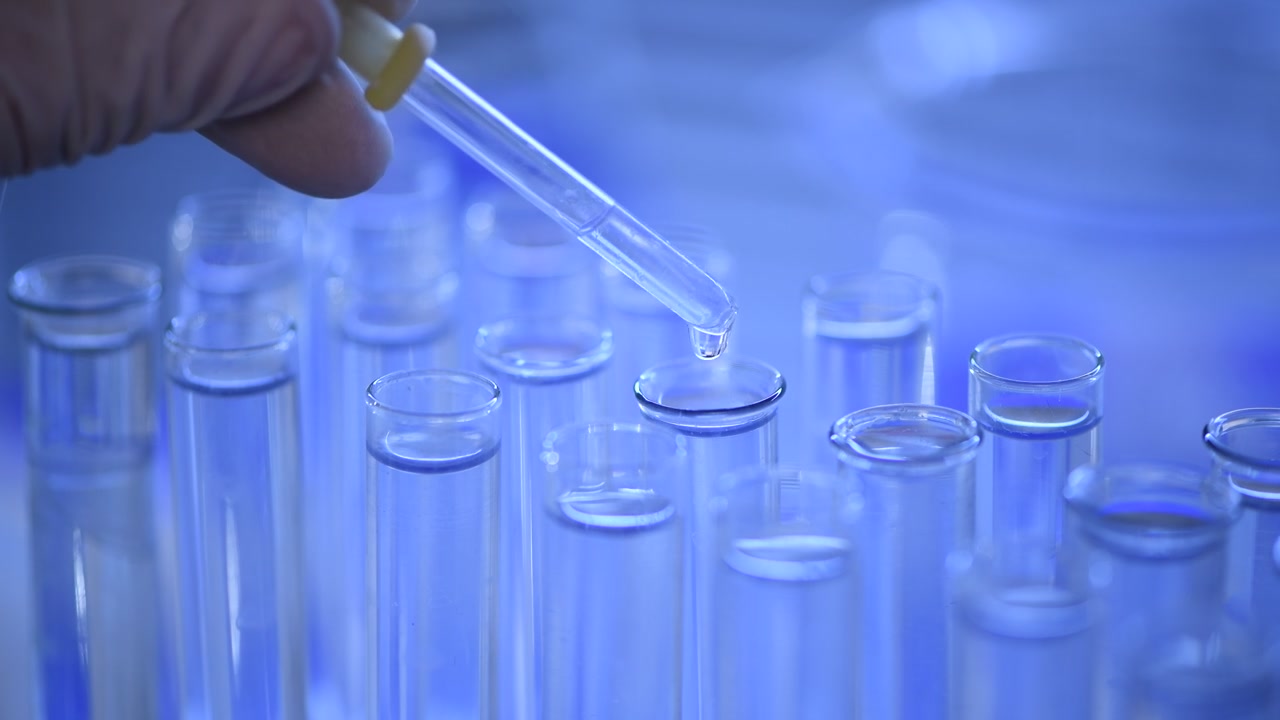 Esperimento di laboratorio con pipetta che fa cadere liquido in una provetta