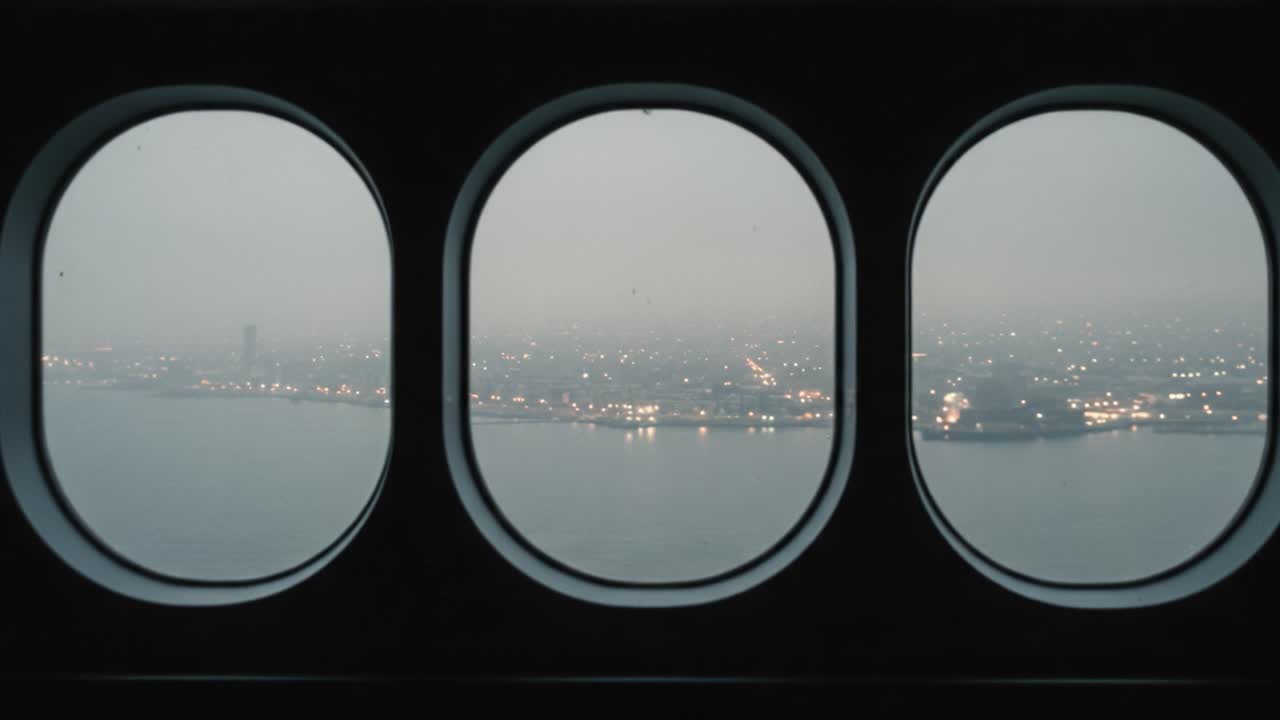 A Serene View Captured Through Porthole Windows, Showcasing a Cityscape Illuminated by Distant Lights Amidst a Misty Atmosphere at Twilight