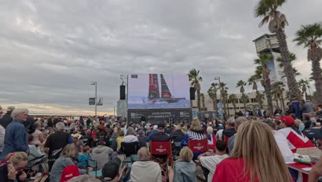crowd outside watching the 37th america´s cup on a giant screen. celebrations