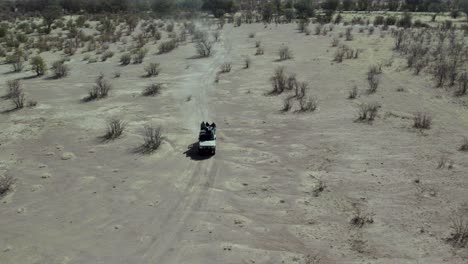 four-wheel drive safari truck driving in african landscape in etosha national park, aerial