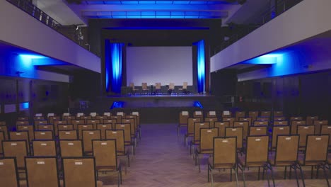 empty conference room with empty chairs on stage - sow motion dolly shot