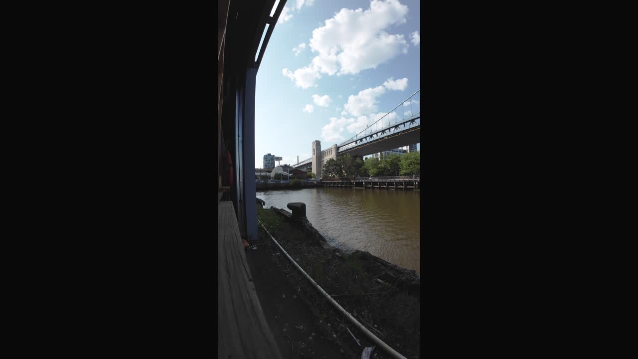 Urban River View with Suspension Bridge and City Skyline