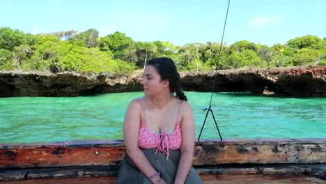 caucasian woman sitting in a wooden boat on a sea safari in africa's blue lagoon