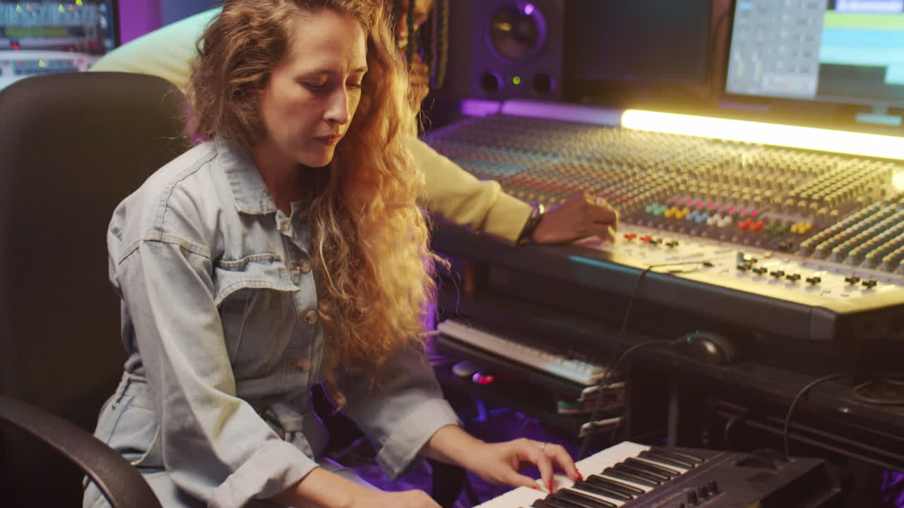 다양한 남녀가 스튜디오에서 음악을 녹음하고 있습니다.