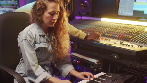 diverse man and woman recording music in studio