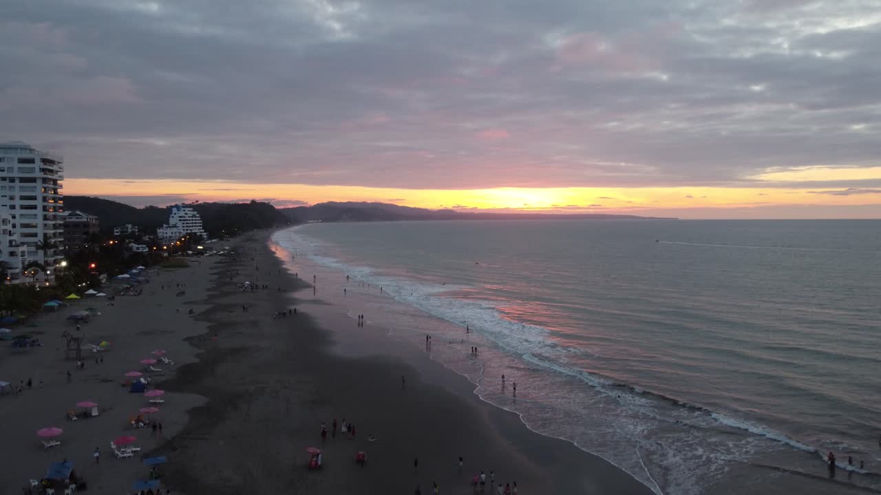 toma de drones de personas disfrutando de la puesta de sol en la misma playa, casa blanca, ecuador