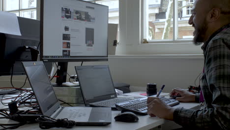 smiling businessman working on laptop computer at home office