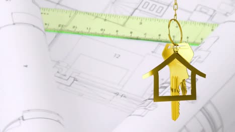 House-keys-and-key-fob-hanging-over-architectural-drawing-in-the-background