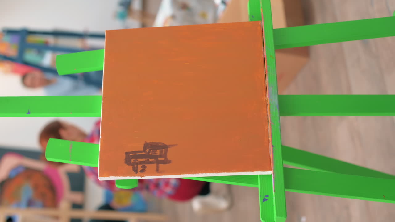 A woman painting a picture using a brush in a studio