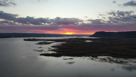 sunset over a river with marsh and woodland