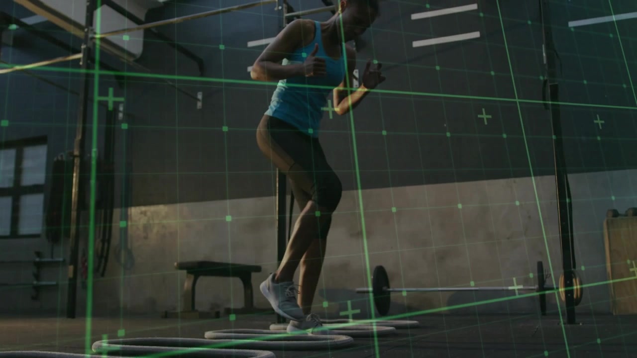 Woman stepping into rings, performing agility drill in gym, green grid tracking motion for fitness