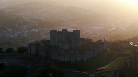 drone glides slowly over dover castle revealing full historic structure and nearby cliffs, establishing overview with historic town in backdrop