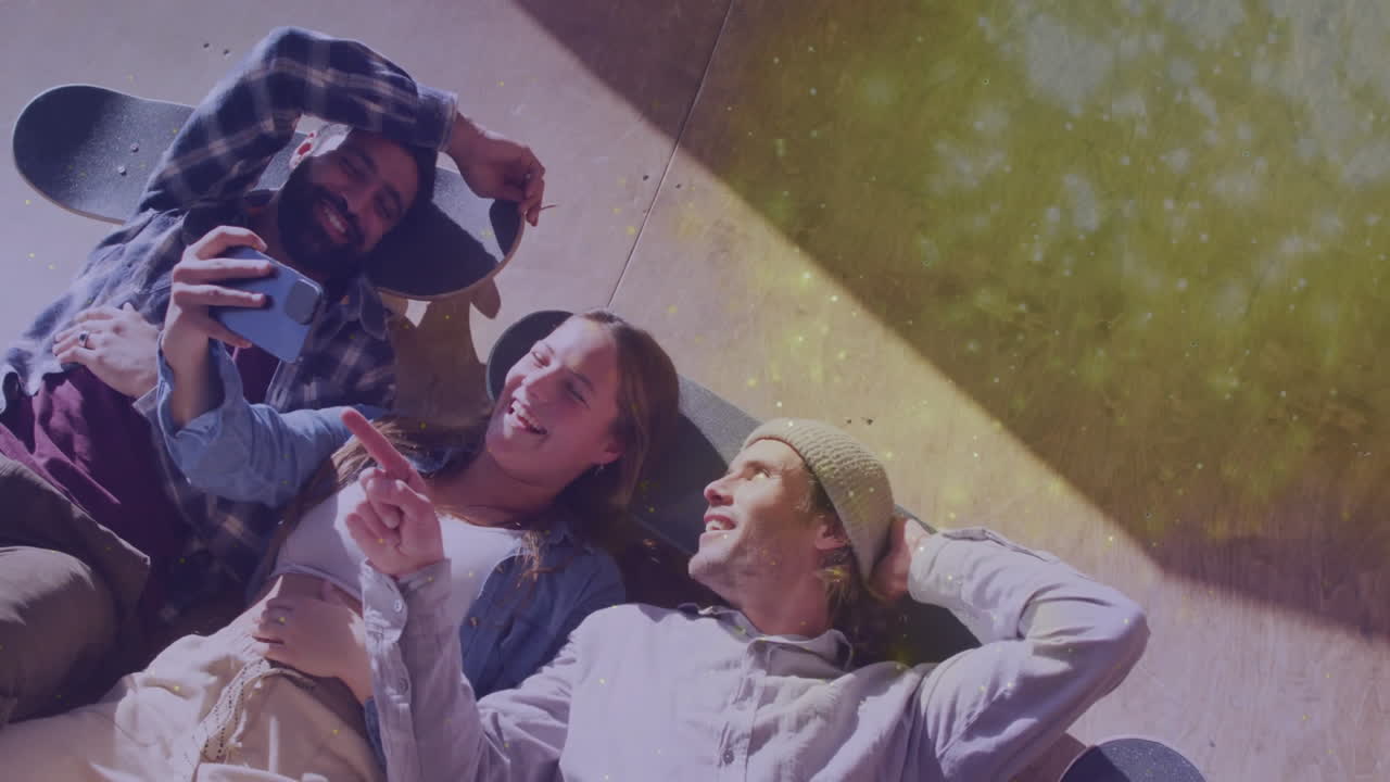 Three skaters lying on wooden ramp, showcasing social media interface and floating dust icons
