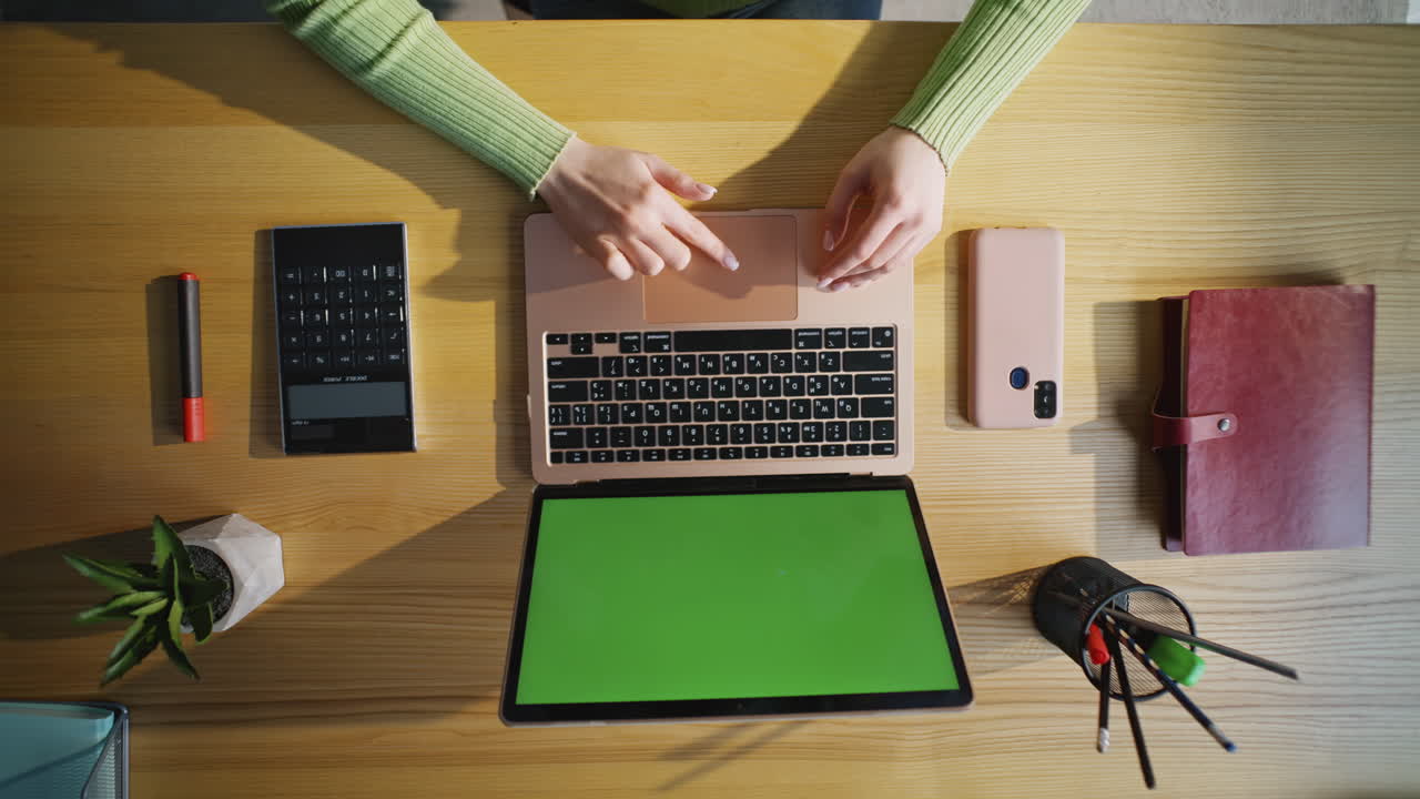 Woman finger touching touchpad using green screen laptop at cabinet top view