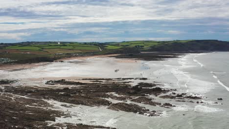 aerial drone flyover beach and rocks in widemouth bay north cornwall