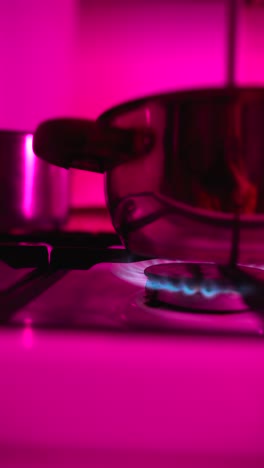 pink lit kitchen stove with pot