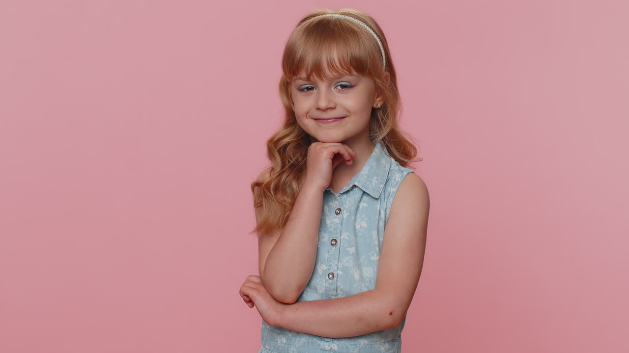 Criança pré-adolescente, menina, alegre e adorável, sorrindo, olhando para a câmera em fundo rosa de estúdio.