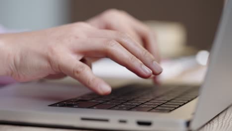 close up hand of a business woman typing keyboard laptop computer on desk office