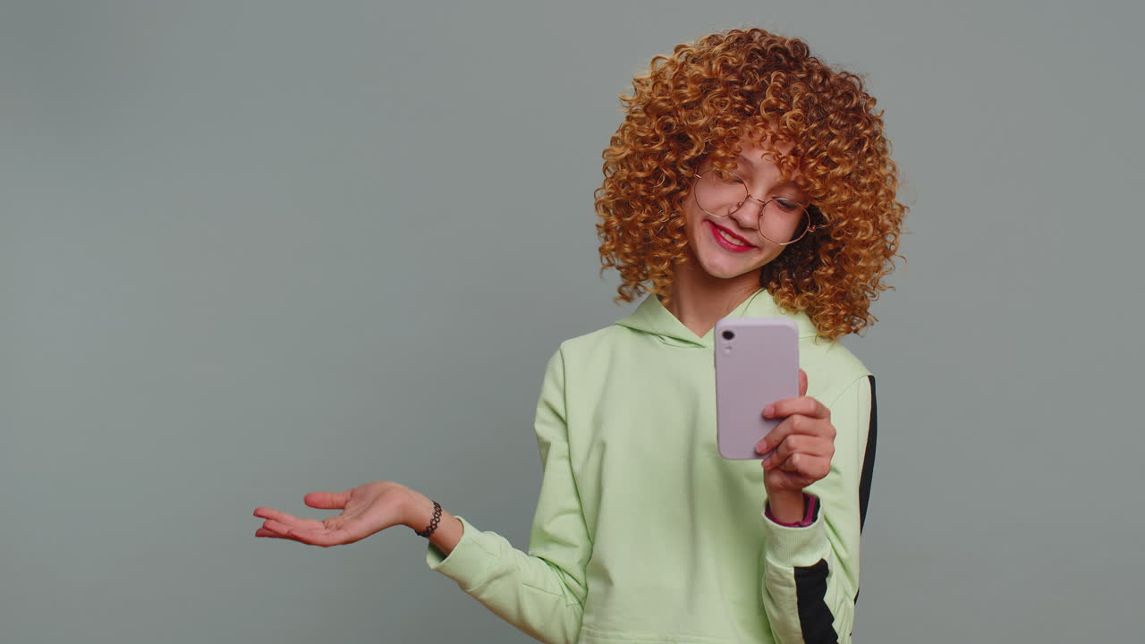 Girl using smartphone pointing empty place positive feedback recommends social networks application