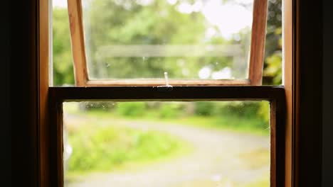 Hand-opening-an-old-wooden-window,-sunshine-outside