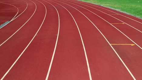 running track at the stadium, color is orange brick, high angle view by drone.