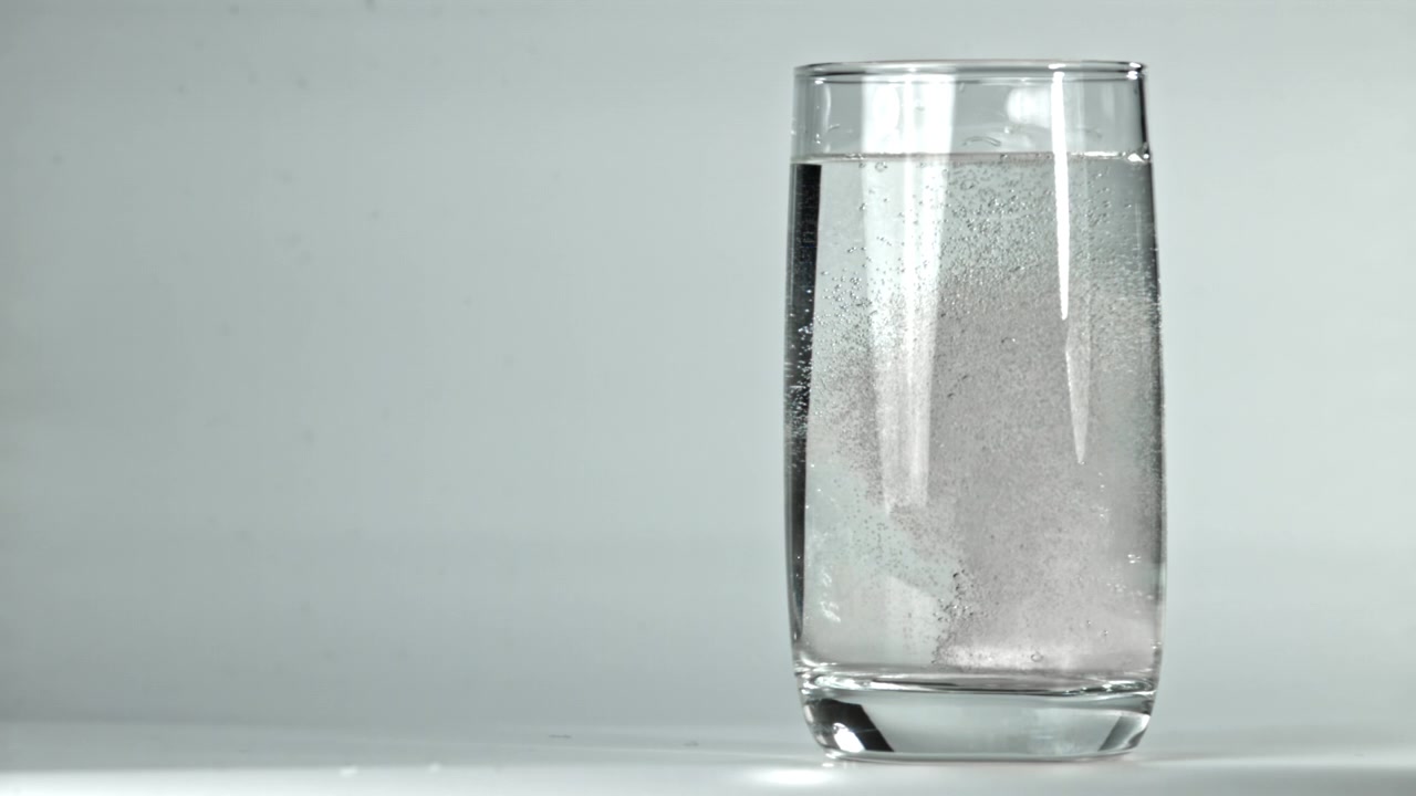 Tavoletta effervescente che si dissolve in un bicchiere d'acqua
