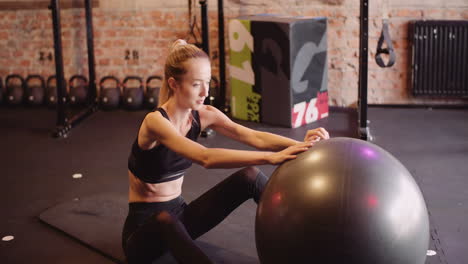 cámara lenta de una hermosa joven delgada haciendo ejercicio con pelota de fitness en el gimnasio